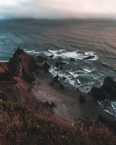 白天海边的褐色岩石山